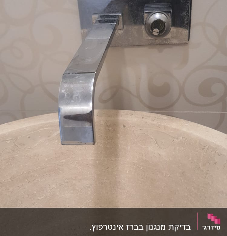 ברז מתכת מעל כיור אבן עגול